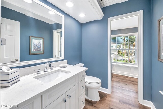 bathroom with toilet, vanity, and hardwood / wood-style flooring