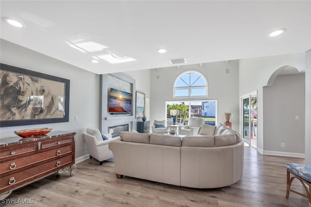 living room with a high ceiling and light wood-type flooring