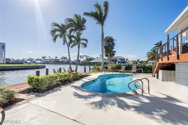 view of swimming pool featuring a patio area and a water view