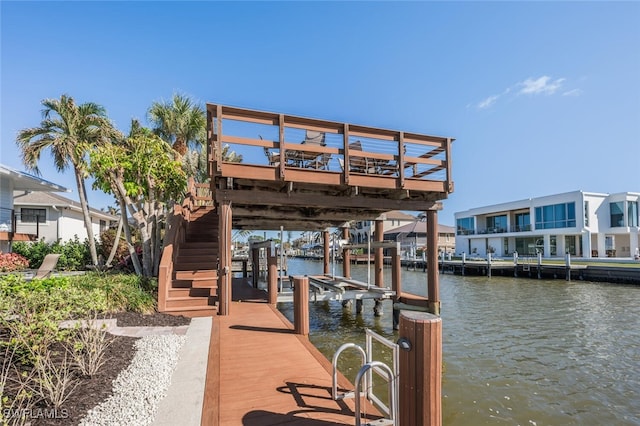 dock area with stairs, a water view, and boat lift