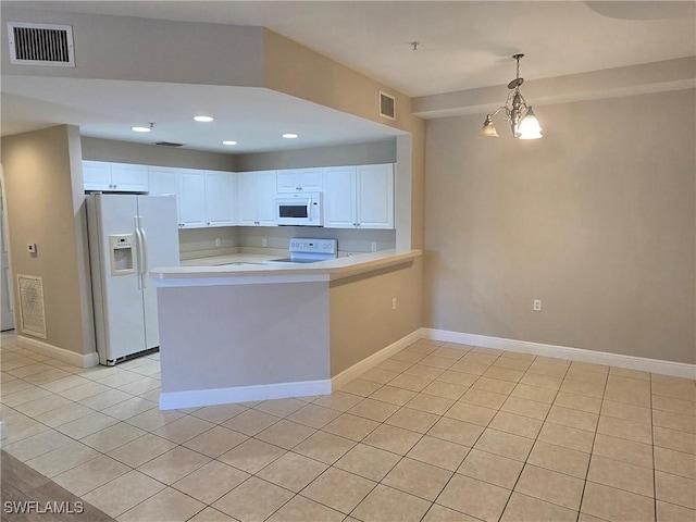 kitchen featuring white appliances, white cabinets, an inviting chandelier, hanging light fixtures, and kitchen peninsula