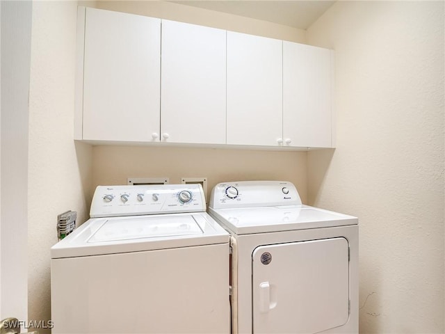 washroom featuring cabinets and independent washer and dryer