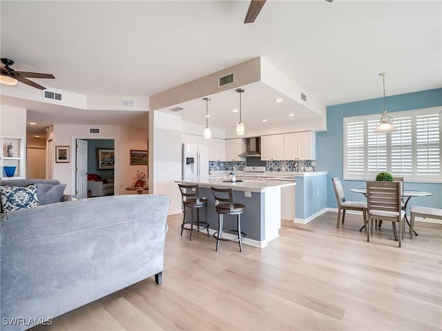 living room with ceiling fan and light wood-type flooring