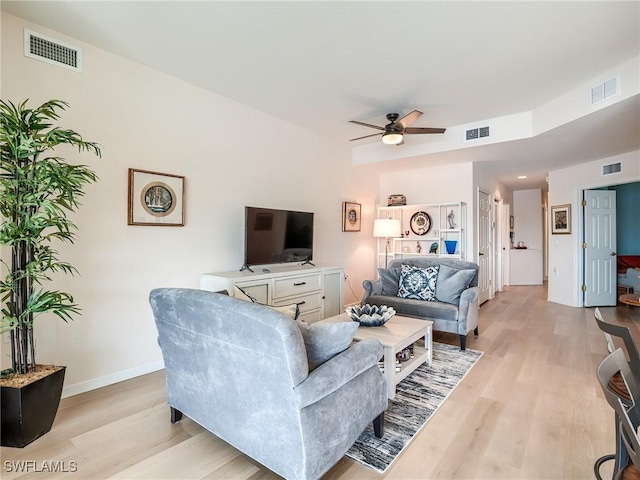 living room with light hardwood / wood-style flooring and ceiling fan