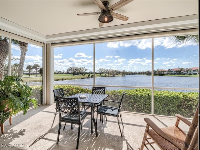 sunroom featuring ceiling fan and a water view