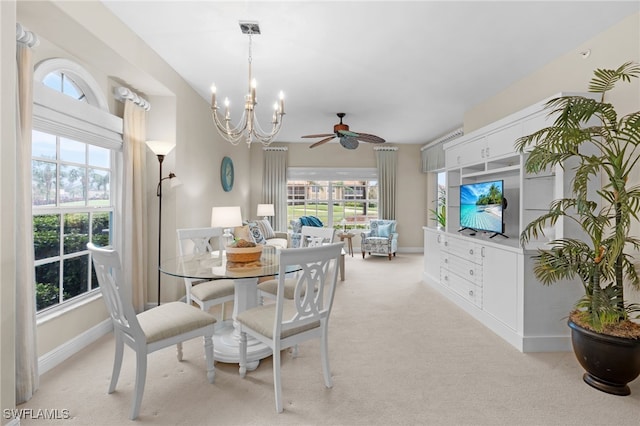 dining room featuring ceiling fan with notable chandelier and light carpet