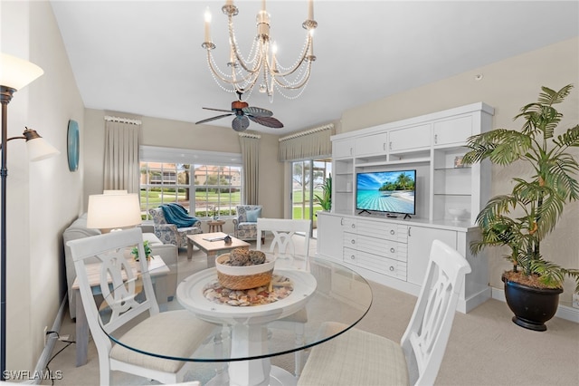 dining space with light carpet and ceiling fan with notable chandelier