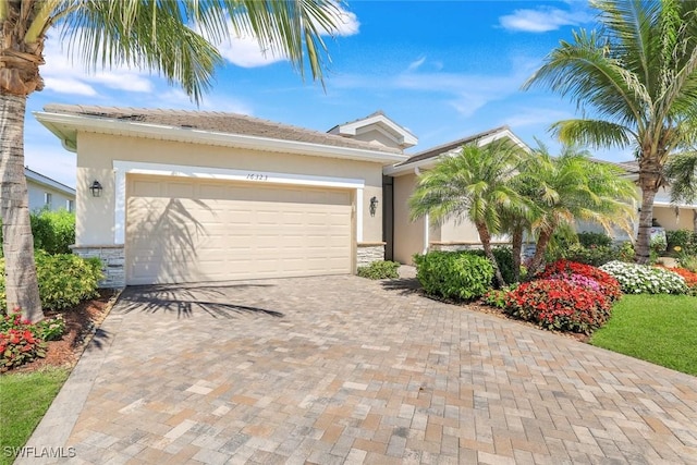 view of front facade with a garage, decorative driveway, and stucco siding