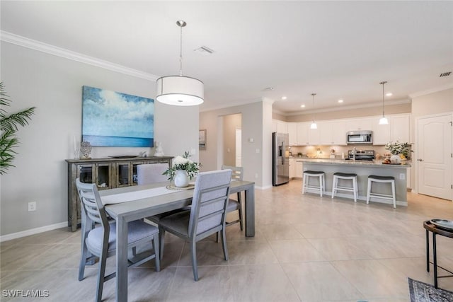 dining room featuring ornamental molding, visible vents, and baseboards