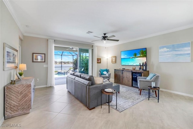 living area featuring wine cooler, light tile patterned floors, visible vents, ornamental molding, and baseboards