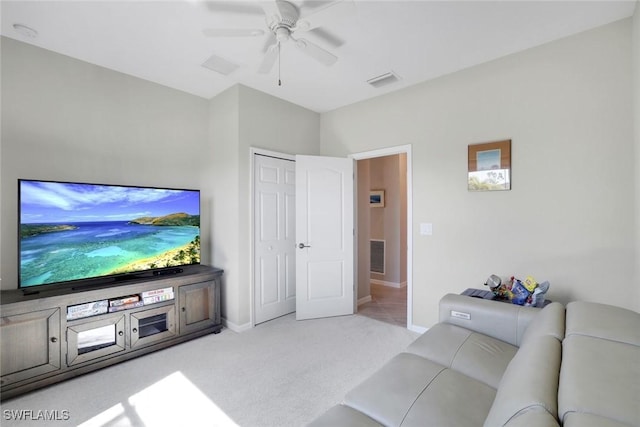 living room with ceiling fan, baseboards, visible vents, and light colored carpet