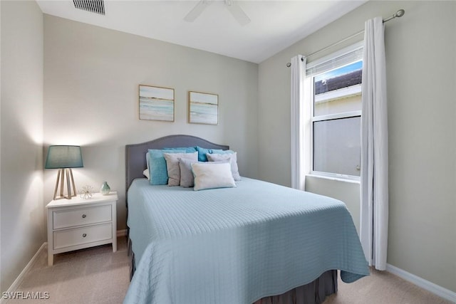 carpeted bedroom featuring a ceiling fan, visible vents, and baseboards