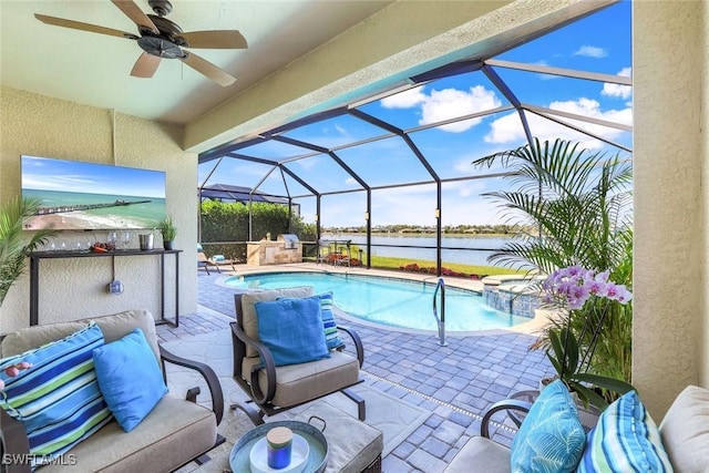 outdoor pool with ceiling fan, glass enclosure, a patio area, and a water view