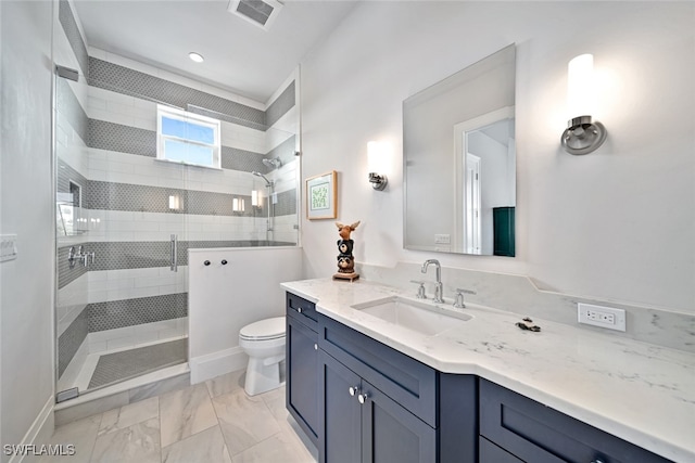 bathroom featuring vanity, toilet, and tiled shower