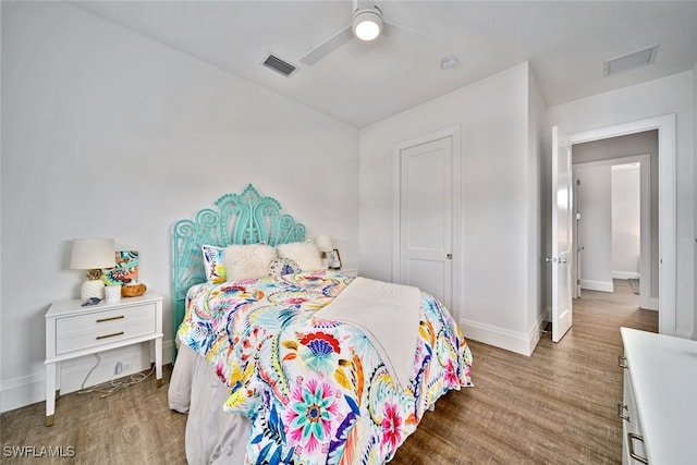 bedroom with hardwood / wood-style flooring, ceiling fan, and a closet