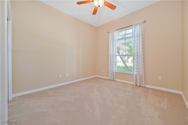 carpeted spare room featuring ceiling fan