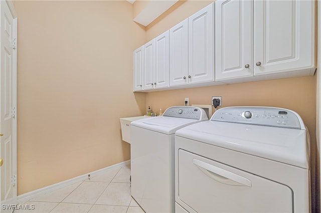 laundry area with cabinets, independent washer and dryer, and light tile patterned floors