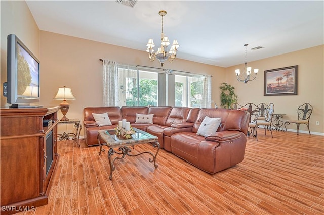 living room with an inviting chandelier and light wood-type flooring