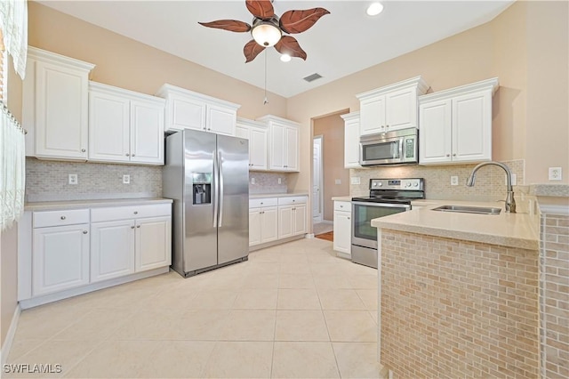 kitchen with sink, white cabinetry, light tile patterned floors, appliances with stainless steel finishes, and ceiling fan