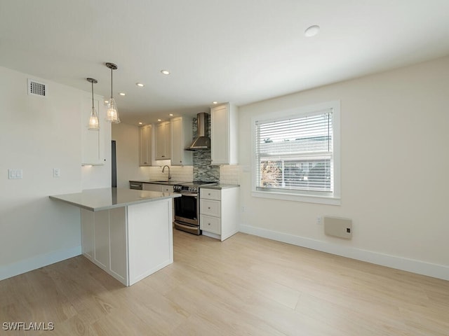 kitchen with white cabinetry, wall chimney exhaust hood, stainless steel electric stove, and kitchen peninsula