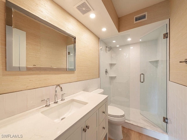 bathroom with vanity, toilet, and a shower with shower door