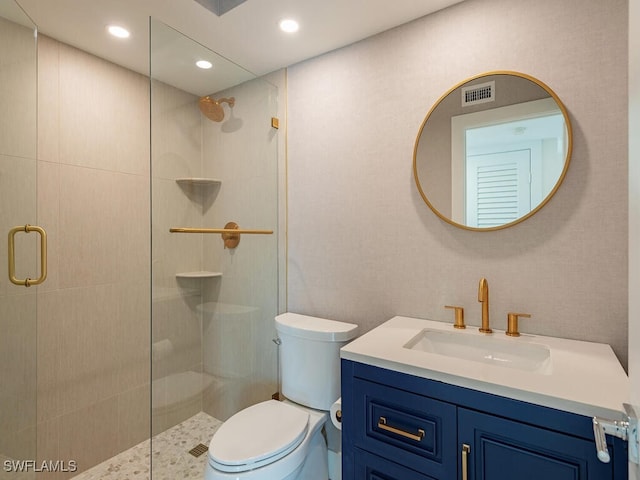 bathroom featuring vanity, toilet, and a shower with shower door