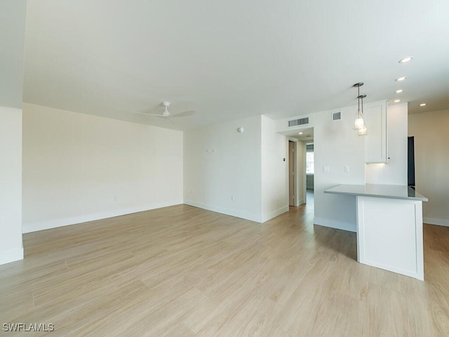 unfurnished living room with ceiling fan and light wood-type flooring