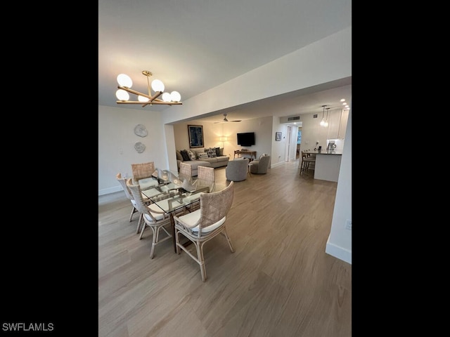 dining space with a notable chandelier and light hardwood / wood-style floors