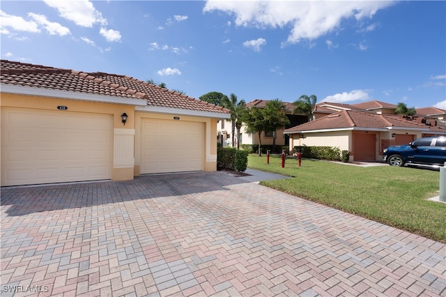 view of front of house featuring a front lawn and a garage