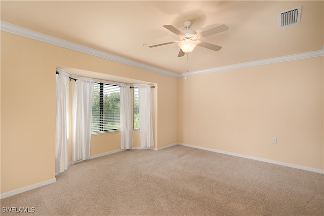 carpeted spare room featuring ceiling fan and crown molding