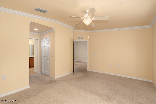 spare room with ceiling fan, light carpet, and crown molding