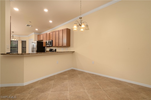 kitchen featuring appliances with stainless steel finishes, dark stone counters, hanging light fixtures, crown molding, and a notable chandelier