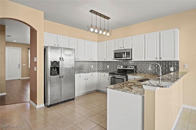 kitchen with white cabinetry, sink, stainless steel appliances, decorative light fixtures, and stone countertops