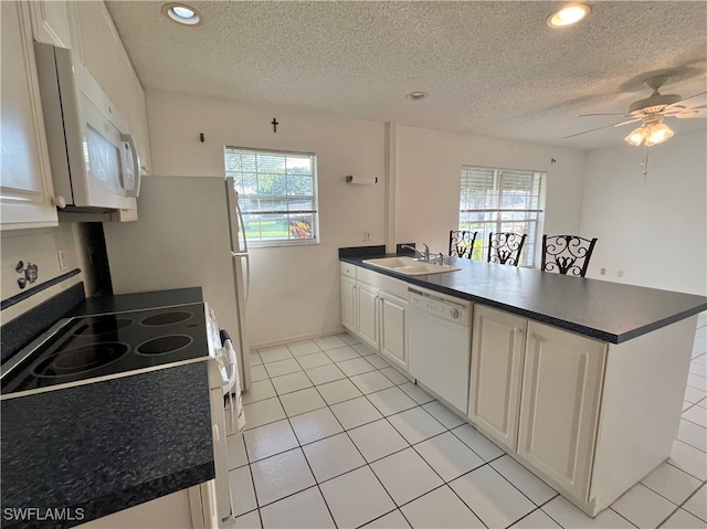 kitchen featuring white appliances, plenty of natural light, sink, and kitchen peninsula