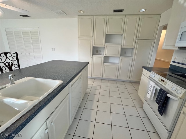 kitchen featuring sink, ceiling fan, light tile patterned flooring, white cabinetry, and white appliances