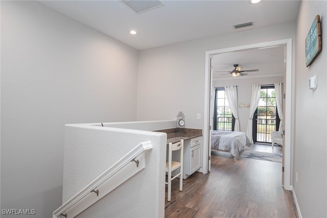 hallway with dark hardwood / wood-style flooring and ornamental molding