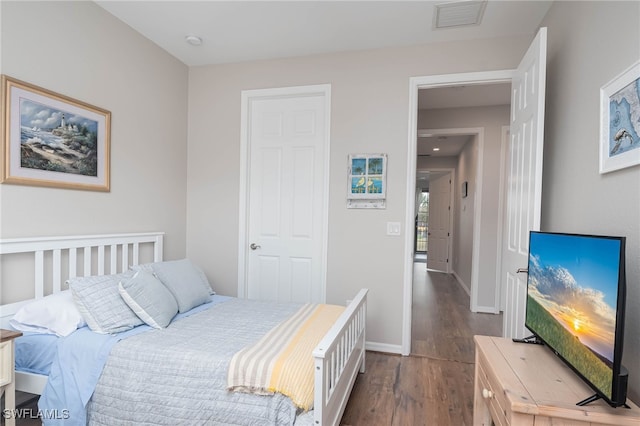 bedroom with dark hardwood / wood-style flooring