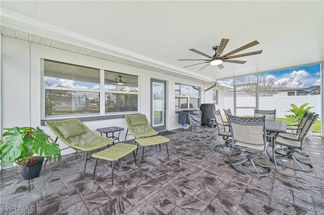 sunroom featuring ceiling fan, a healthy amount of sunlight, and beam ceiling