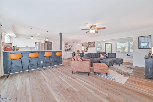 living room featuring light wood-type flooring and ceiling fan