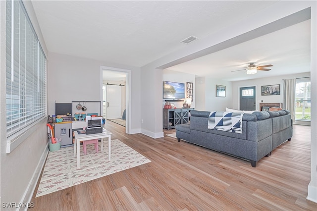 living room with light hardwood / wood-style floors and ceiling fan