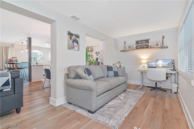 living room featuring sink and light hardwood / wood-style flooring