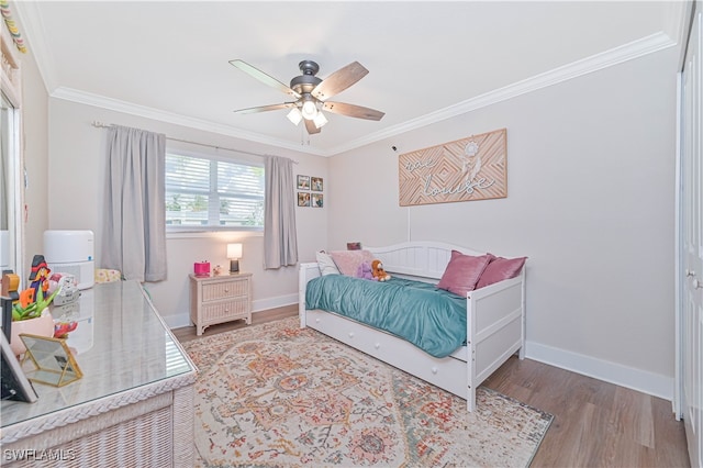 bedroom with hardwood / wood-style floors, ceiling fan, and crown molding