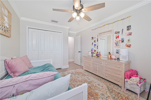 bedroom with ceiling fan, a closet, light wood-type flooring, and ornamental molding