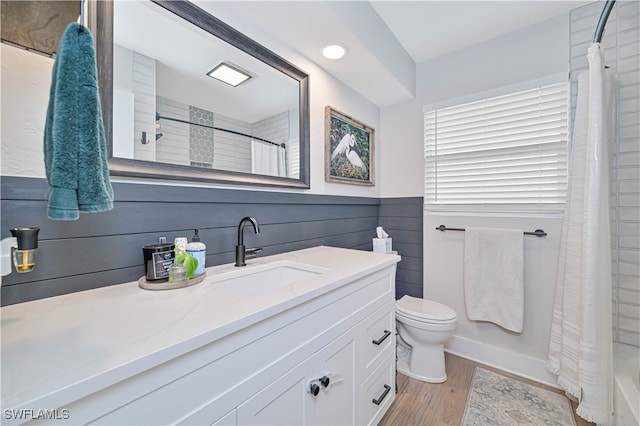 full bathroom featuring shower / bath combo, wood-type flooring, toilet, and vanity