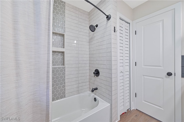 bathroom featuring wood-type flooring and shower / bathtub combination with curtain