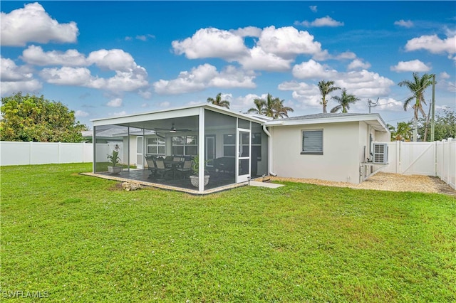 back of property with a lawn, ceiling fan, a sunroom, and a patio area