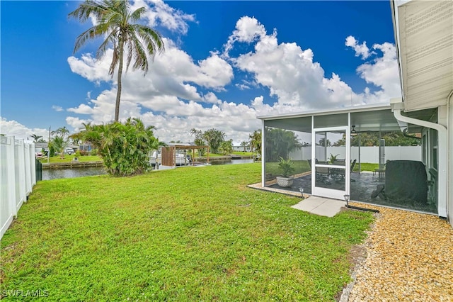 view of yard with a sunroom and a water view