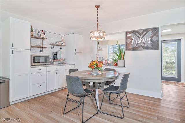 dining area with a wealth of natural light, a notable chandelier, and light hardwood / wood-style floors