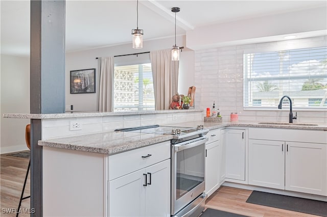 kitchen with decorative backsplash, stainless steel electric range oven, sink, and white cabinets