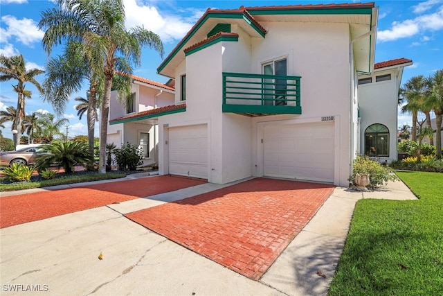2233 Anchorage Ln Unit B, Naples, FL 34104 - view of front of house featuring stucco siding, decorative driveway, a balcony, and a garage